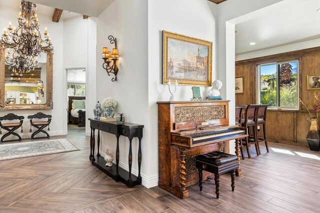 miscellaneous room with a chandelier, beamed ceiling, and parquet floors