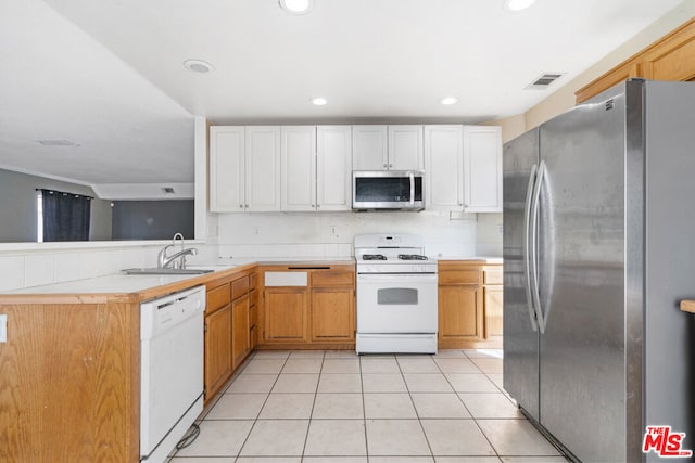 kitchen featuring sink, white cabinetry, light tile patterned floors, and appliances with stainless steel finishes