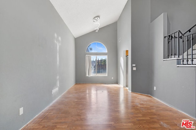 interior space with high vaulted ceiling and hardwood / wood-style floors