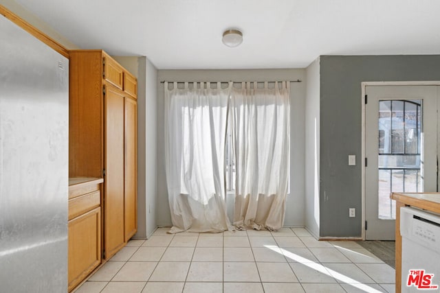 kitchen featuring light tile patterned floors, plenty of natural light, and dishwasher