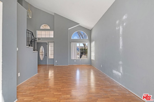 entrance foyer featuring high vaulted ceiling and hardwood / wood-style floors