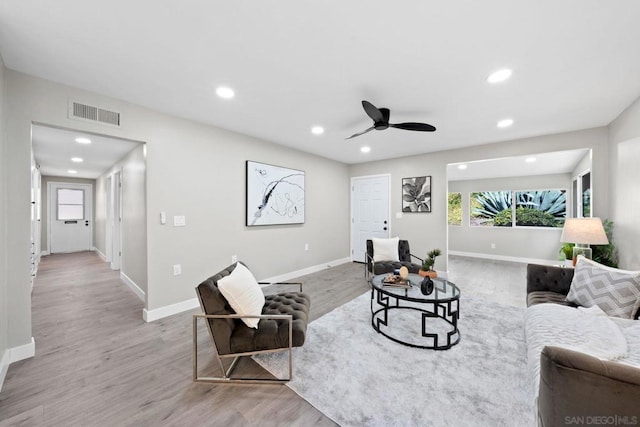 living room with light wood-type flooring and ceiling fan