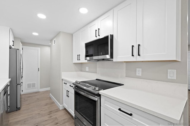 kitchen featuring white cabinets, stainless steel appliances, and light wood-type flooring