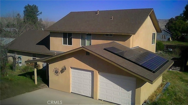 view of front of house featuring a garage and solar panels