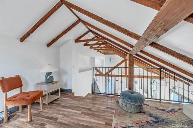 sitting room with wood-type flooring and lofted ceiling with beams