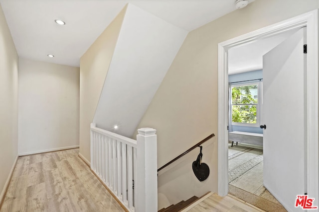 hallway featuring light hardwood / wood-style floors and lofted ceiling