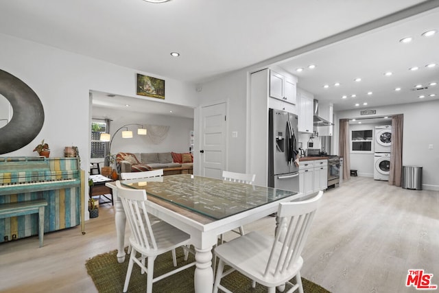 dining room featuring light hardwood / wood-style flooring and stacked washing maching and dryer