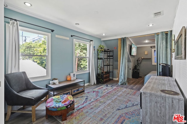 sitting room with plenty of natural light, dark wood-type flooring, and ornamental molding