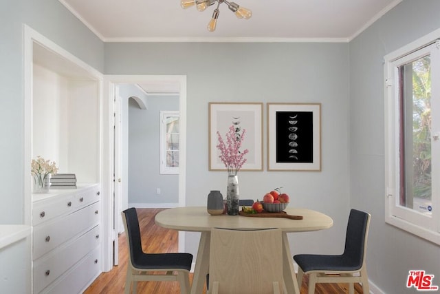 dining area featuring crown molding and light wood-type flooring