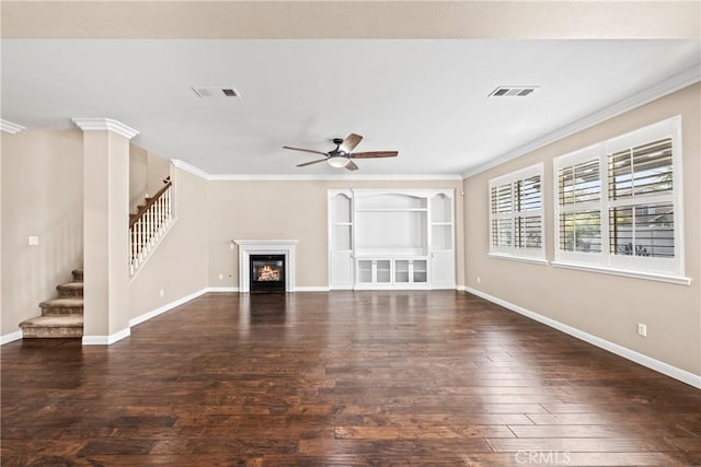 unfurnished living room with ornate columns, crown molding, dark wood-type flooring, and ceiling fan