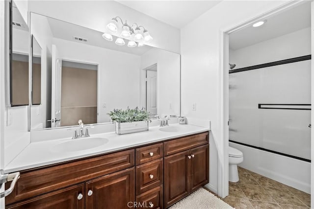 full bathroom with bath / shower combo with glass door, vanity, toilet, and tile patterned flooring