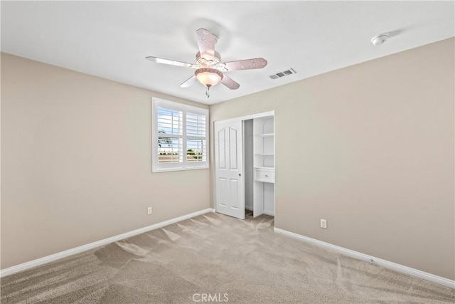 carpeted spare room with ceiling fan