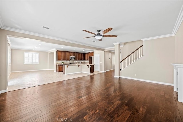 unfurnished living room featuring crown molding, wood-type flooring, and ceiling fan