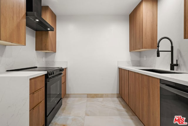 kitchen with sink, black appliances, and wall chimney range hood