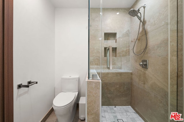 bathroom featuring toilet and tiled shower