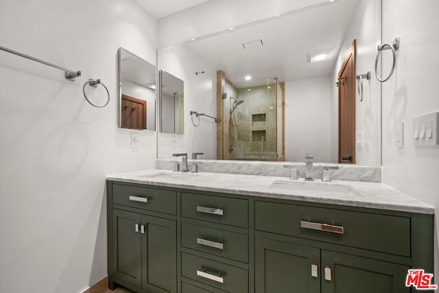 bathroom featuring a shower with shower door and vanity