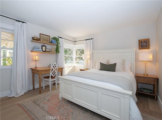 bedroom featuring multiple windows and light wood-type flooring