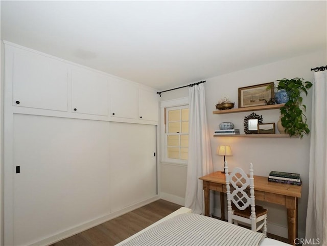 bedroom featuring hardwood / wood-style flooring, a closet, and built in desk