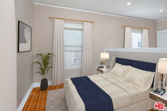 bedroom with wood-type flooring and crown molding