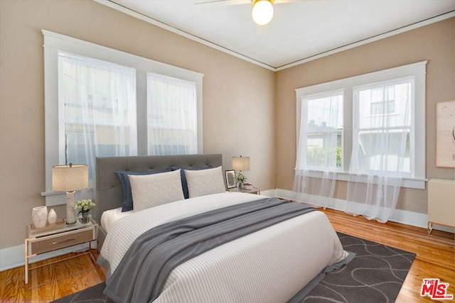 bedroom featuring hardwood / wood-style floors, ceiling fan, and ornamental molding