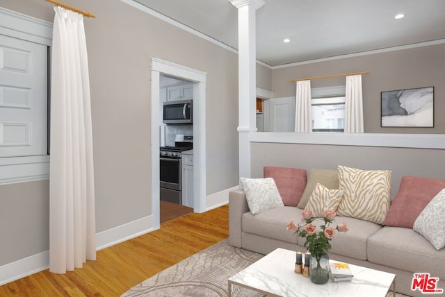 living room with crown molding, hardwood / wood-style floors, and decorative columns