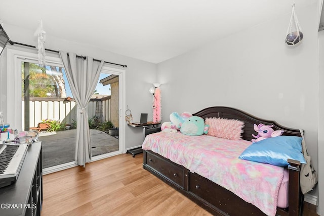 bedroom featuring access to exterior and light hardwood / wood-style flooring