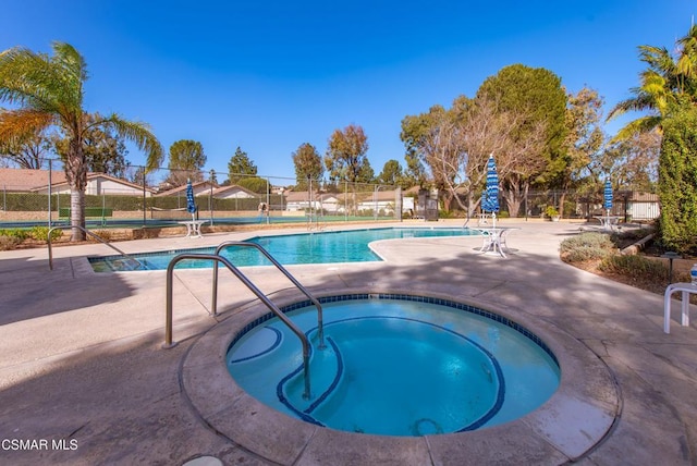 view of swimming pool featuring a patio area and a community hot tub