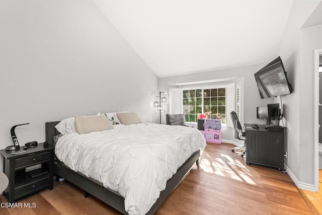 bedroom featuring vaulted ceiling and hardwood / wood-style floors