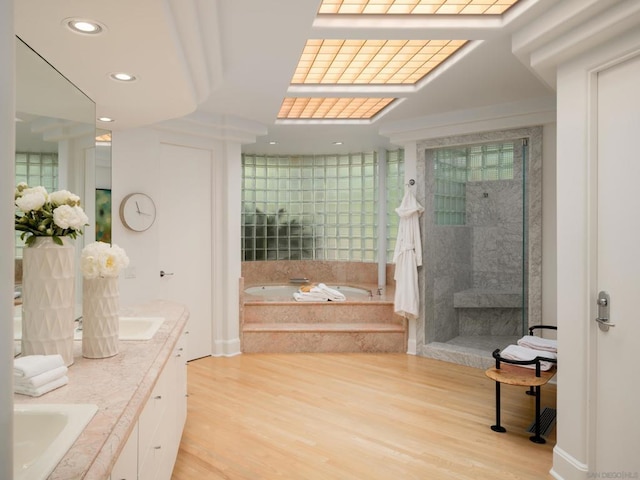 bathroom with vanity, wood-type flooring, and plus walk in shower