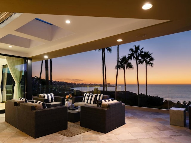 patio terrace at dusk featuring a water view and outdoor lounge area