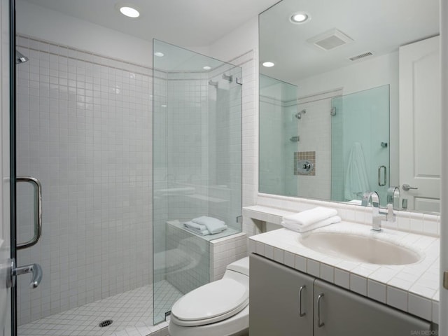 bathroom featuring a shower with door, toilet, and vanity