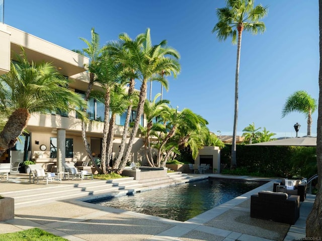 view of pool featuring a patio area and exterior fireplace