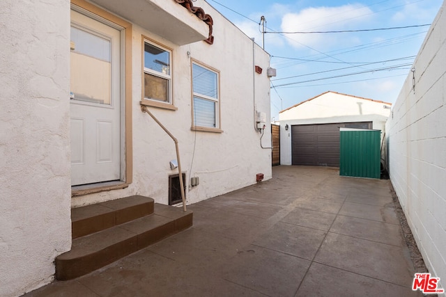 view of home's exterior with a garage and an outbuilding