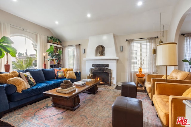 living room featuring lofted ceiling and a fireplace