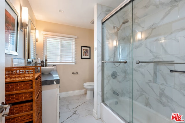 full bathroom with enclosed tub / shower combo, vanity, and toilet