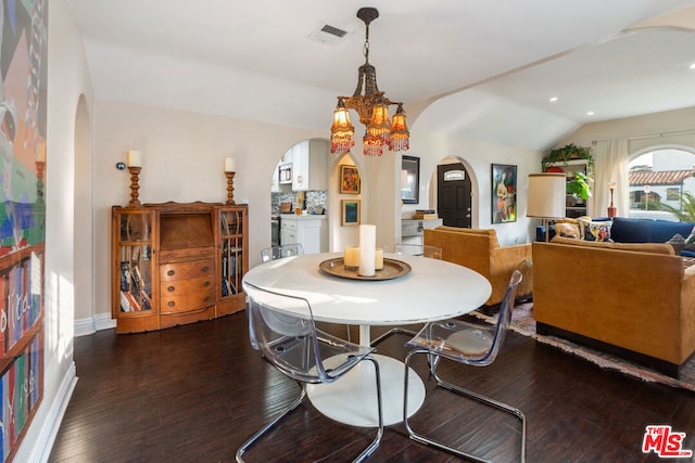 dining room with dark hardwood / wood-style floors, a notable chandelier, and vaulted ceiling