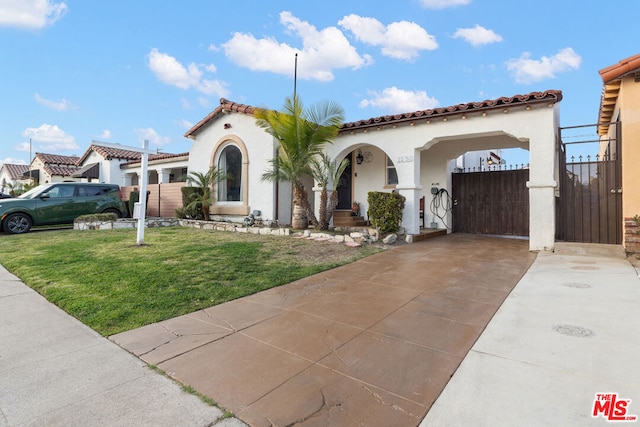 mediterranean / spanish home featuring a front yard and a carport