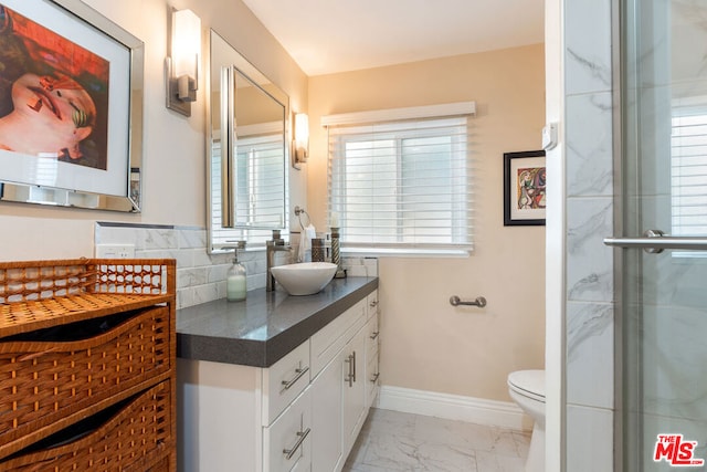 bathroom with toilet, tasteful backsplash, a wealth of natural light, and vanity