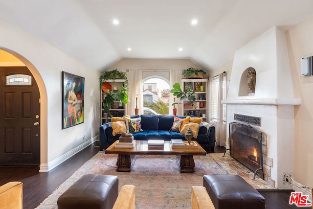 living room featuring a large fireplace, wood-type flooring, and lofted ceiling