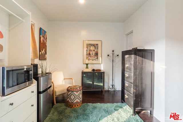 bedroom with dark wood-type flooring and stainless steel fridge