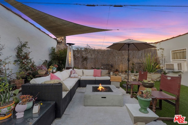 patio terrace at dusk with an outdoor living space with a fire pit