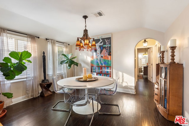 dining area featuring plenty of natural light, a chandelier, vaulted ceiling, and dark hardwood / wood-style flooring