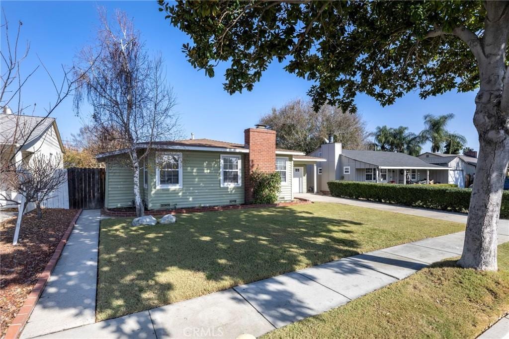 single story home featuring a front lawn