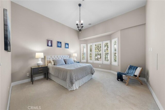 bedroom featuring light colored carpet and a notable chandelier