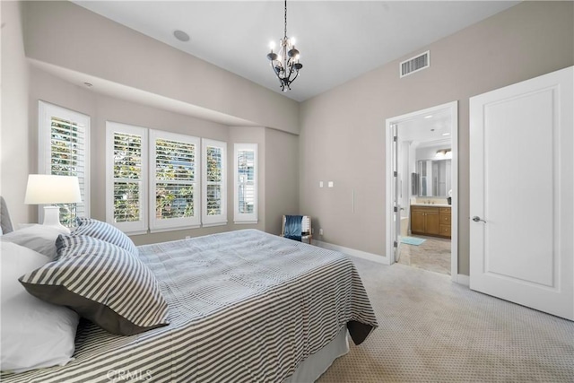 carpeted bedroom with ensuite bathroom, an inviting chandelier, and multiple windows