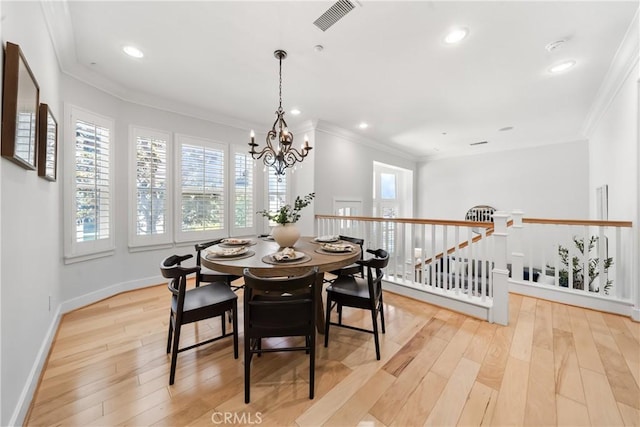 dining room with ornamental molding, light hardwood / wood-style flooring, and a notable chandelier