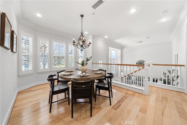 dining area featuring crown molding, plenty of natural light, and light wood-style floors