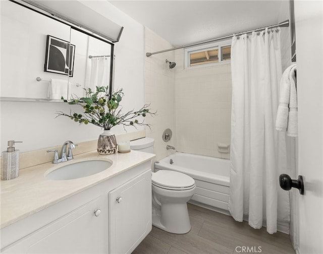 full bathroom featuring vanity, hardwood / wood-style flooring, shower / bath combination with curtain, and toilet