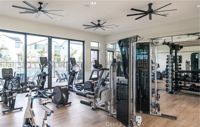 exercise room with light hardwood / wood-style floors, ornamental molding, and ceiling fan