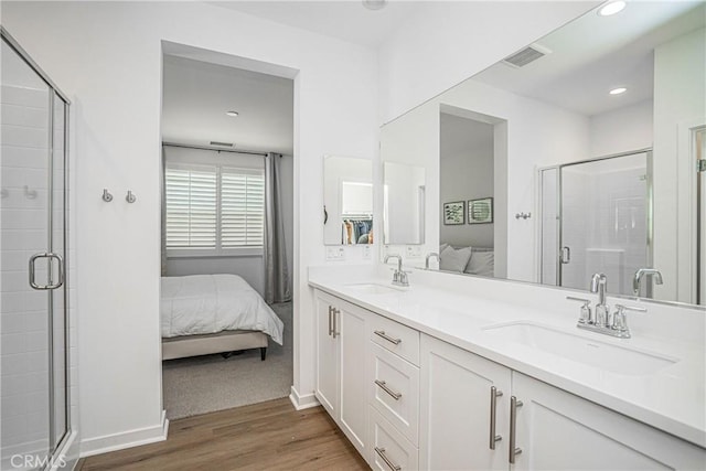 bathroom featuring a shower with shower door, hardwood / wood-style floors, and vanity